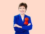 Editorial illustration of a woman in a blue blazer with arms crossed wearing a red 2nd place ribbon labeled Least Popular Above Replacement Senator.