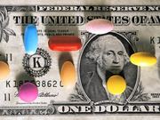 Editorial illustration showing colorful pills and tablets scattered across a US one-dollar bill, symbolizing drug costs or healthcare spending.