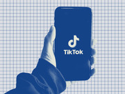 Blue-tinted editorial illustration of a hand holding a smartphone displaying the TikTok logo on a grid-paper background.
