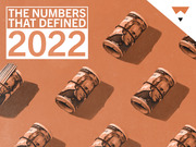 Editorial illustration with rolled-up $20 bills on an orange background and the headline The Numbers That Defined 2022.