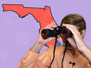 Editorial illustration of a person looking through binoculars in front of a red-shaded map of Florida on a purple background.