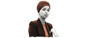 Stylized editorial illustration of a woman wearing a rust-colored head wrap and dark blazer, rendered in a duotone black-and-white with color accents.
