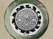 Editorial illustration of a sewer manhole cover surrounded by dark blob shapes resembling coronavirus particles, set against concentric green circles on a tan background.