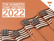 Editorial illustration with American flags on an orange background and the text The Numbers That Defined 2022.