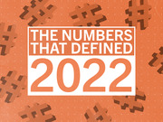 Decorative editorial title graphic reading 'The Numbers That Defined 2022' on an orange background with hashtag symbols.