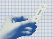 A blue-tinted editorial illustration of a hand holding a SARS-CoV-2 rapid antigen test against a grid-paper background.