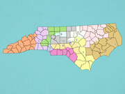 Color-coded map of North Carolina showing 13 numbered congressional districts, each district filled with a distinct color.