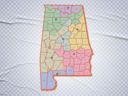 Color-coded map of Alabama showing its 7 congressional districts overlaid on county boundaries, printed on a wrinkled white grid-paper background.