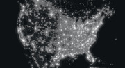 Grayscale night-lights map of North America showing population density and urban light distribution across the United States and Canada.