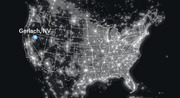 Dark satellite-style map of the contiguous United States showing light pollution or population density, with Gerlach, NV marked by a blue pin in a notably dark region.