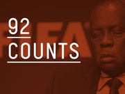 Red-tinted editorial graphic showing the number 92 counts overlaid on a photo of a man in front of a FIFA backdrop.