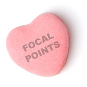 A pink candy heart with the words FOCAL POINTS stamped on it, styled like a Valentine's Day conversation heart candy.