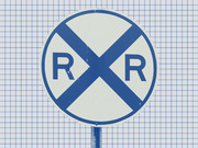 A blue and white railroad crossing sign with an X and the letters R R, set against a grid-paper background.