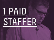Purple-tinted editorial graphic showing a man with glasses overlaid with large white text reading '1 Paid Staffer', indicating a campaign staffing statistic.