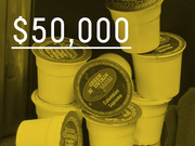 Yellow-tinted photo of K-cup coffee pods with large white text overlay showing $50,000, used as a data-driven editorial graphic.