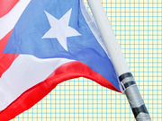 Puerto Rico flag waving on a pole against a yellow grid-paper background, used as editorial illustration.