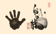 Two ink handprints side by side with Japanese or Chinese calligraphy and red seal stamps on a cream background.