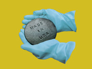 Editorial illustration of blue rubber gloves holding a metal disc stamped with Made In USA on a yellow background.