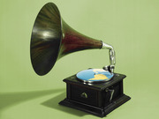 A vintage gramophone with a world map replacing the record on its turntable, set against a green background.