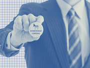 Blue-tinted editorial photo of a suited person holding a campaign button featuring the Democratic donkey and the text Somewhat Liberal.