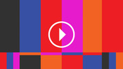 Colorful geometric grid of vertical and horizontal color bars in red, blue, magenta, orange, and black with a white play button icon in the center.