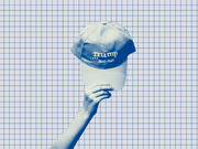 Blue-tinted editorial illustration of a hand holding up a Trump 2020 campaign cap against a grid-paper background.