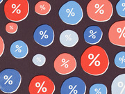 Decorative editorial illustration featuring red and blue circles of varying sizes with percentage signs on a dark background.