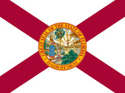 The state flag of Florida featuring a red diagonal cross on white background with the Great Seal of the State of Florida at center.