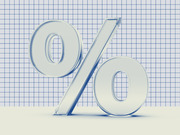 A 3D glass-rendered percent sign standing against a blue grid graph-paper background, used as decorative editorial art.