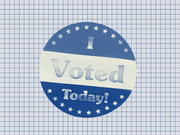 Illustrated I Voted Today sticker in blue and white with stars, on a grid paper background.