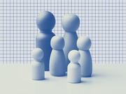 Blue-tinted photo of wooden peg doll figures of varying sizes arranged together against a grid paper background, representing a family group.