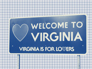 Illustrated Welcome to Virginia road sign with heart icon and Virginia Is For Lovers slogan on a grid paper background.
